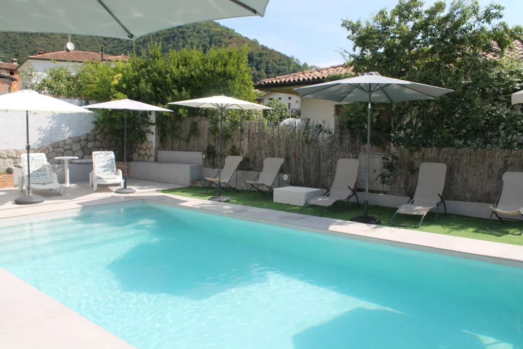 Piscina all'aperto con lettini prendisole nel giardino recintato de La Corte di Marga a Miane