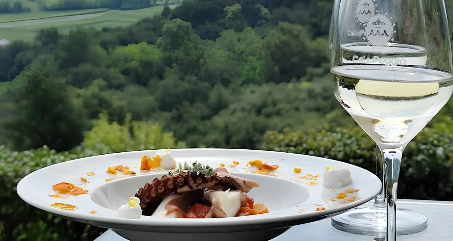 Piatto di pesce e calice di vino sulla terrazza di Ca' del Poggio
