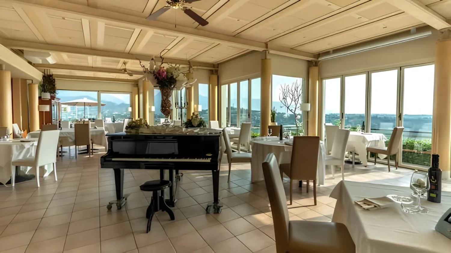 Sala interna panoramica di Ca' del Poggio con pianoforte e vista sulle colline
