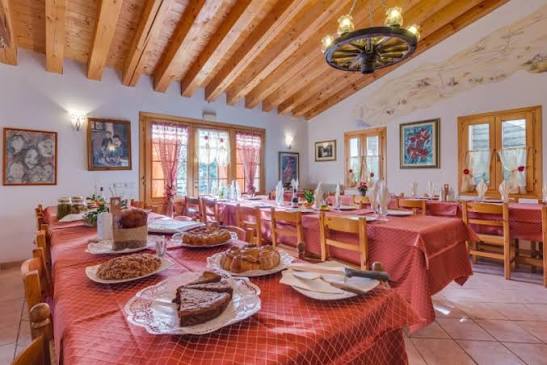 Sala interna del ristorante Claudia Augusta Altinate, travi in legno e tovaglie a quadretti