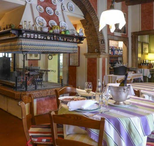 Sala interna di Osteria Al Castelletto Dalla Clemi con il grande camino per la cottura della carne alla brace