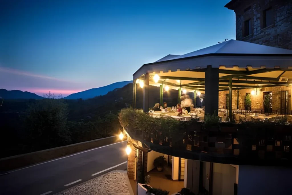 Terrazza coperta del ristorante Andreetta a Rolle illuminata al tramonto, con vista sulle colline