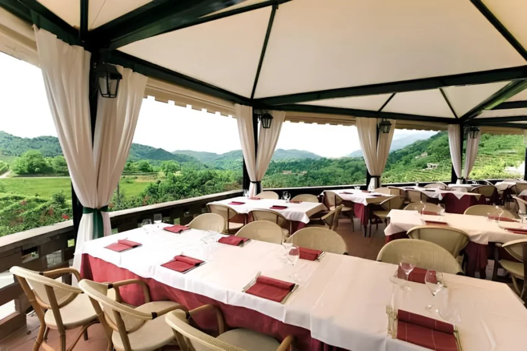 Terrazza panoramica del ristorante Andreetta apparecchiata di giorno, con vista sulla vallata dei vigneti